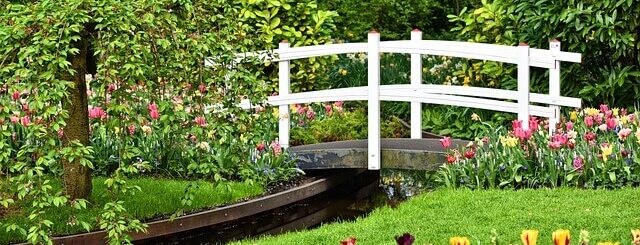 Prachtige tuin met brug, gazon en bloemen