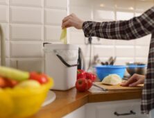 vrouw die bokashi compost maakt in de keuken