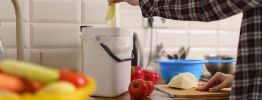 vrouw die bokashi compost maakt in de keuken