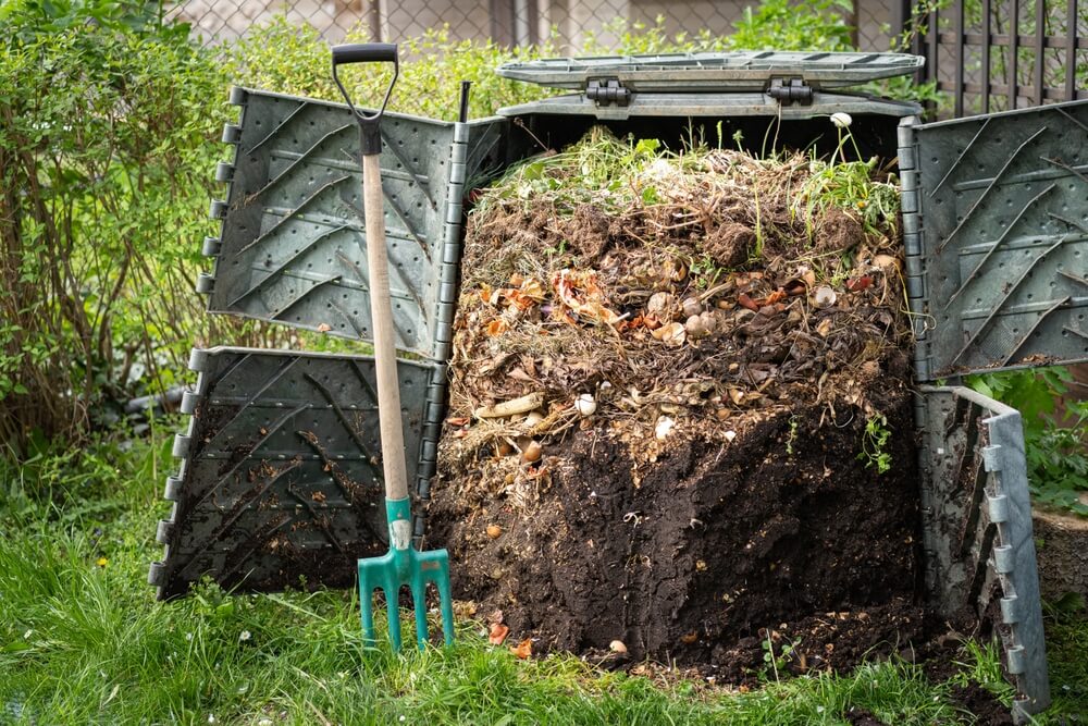 Een overdekte composthoop in de tuin