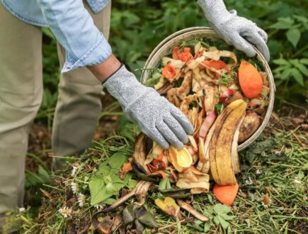 Iemand gooit fruit- en groenteschillen in de tuin